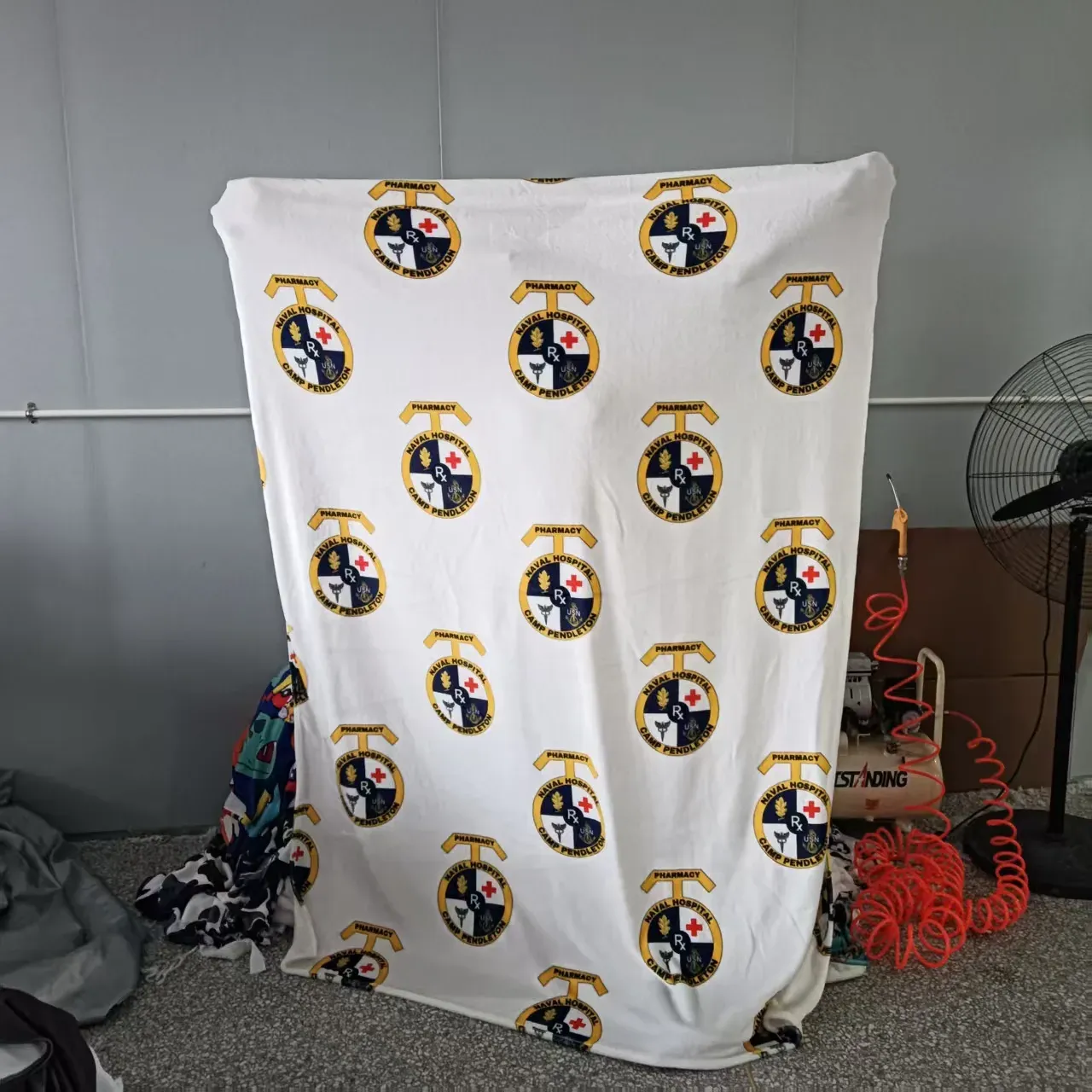 Custom printed fleece blanket with full-color racing car artwork hanging on display