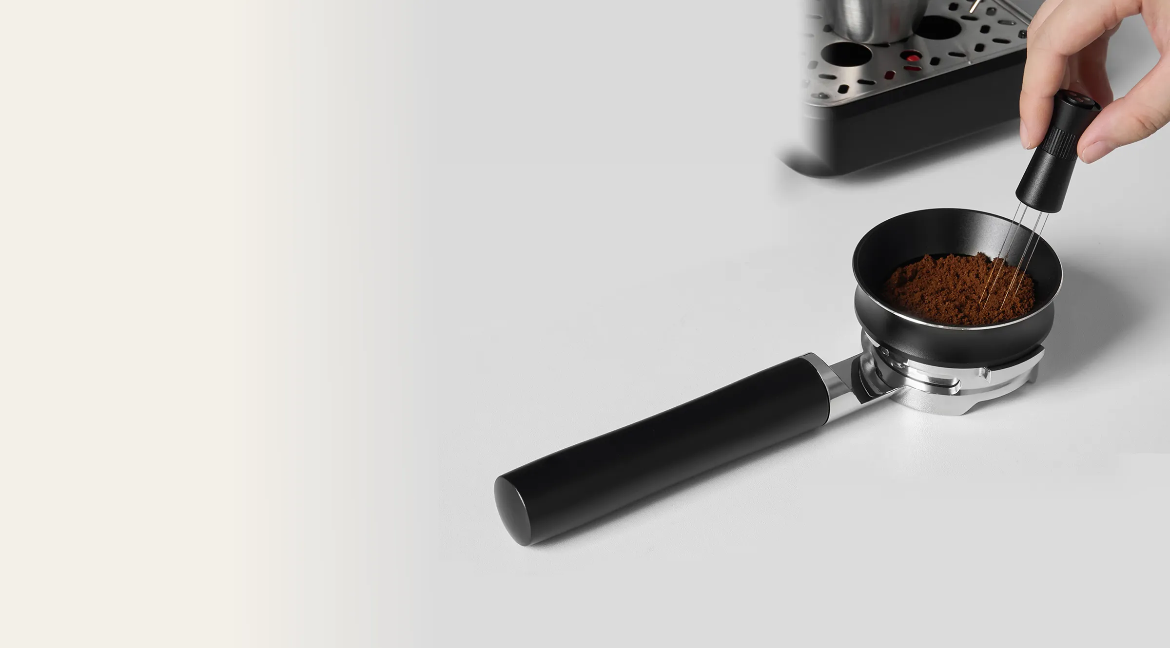 KHC-B10 portafilter with ground coffee being prepared beside an espresso machine.