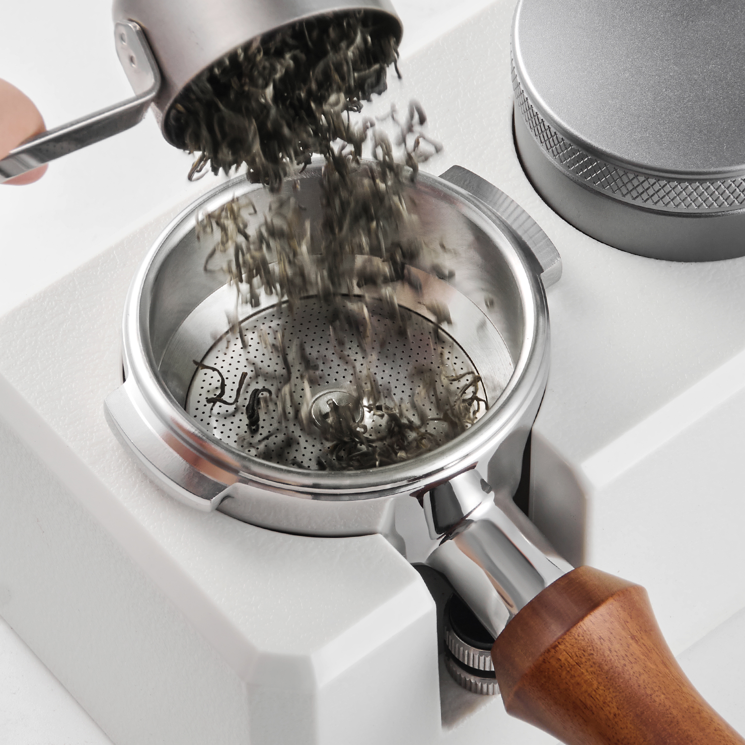 Tea leaves being loaded into a tea extraction portafilter