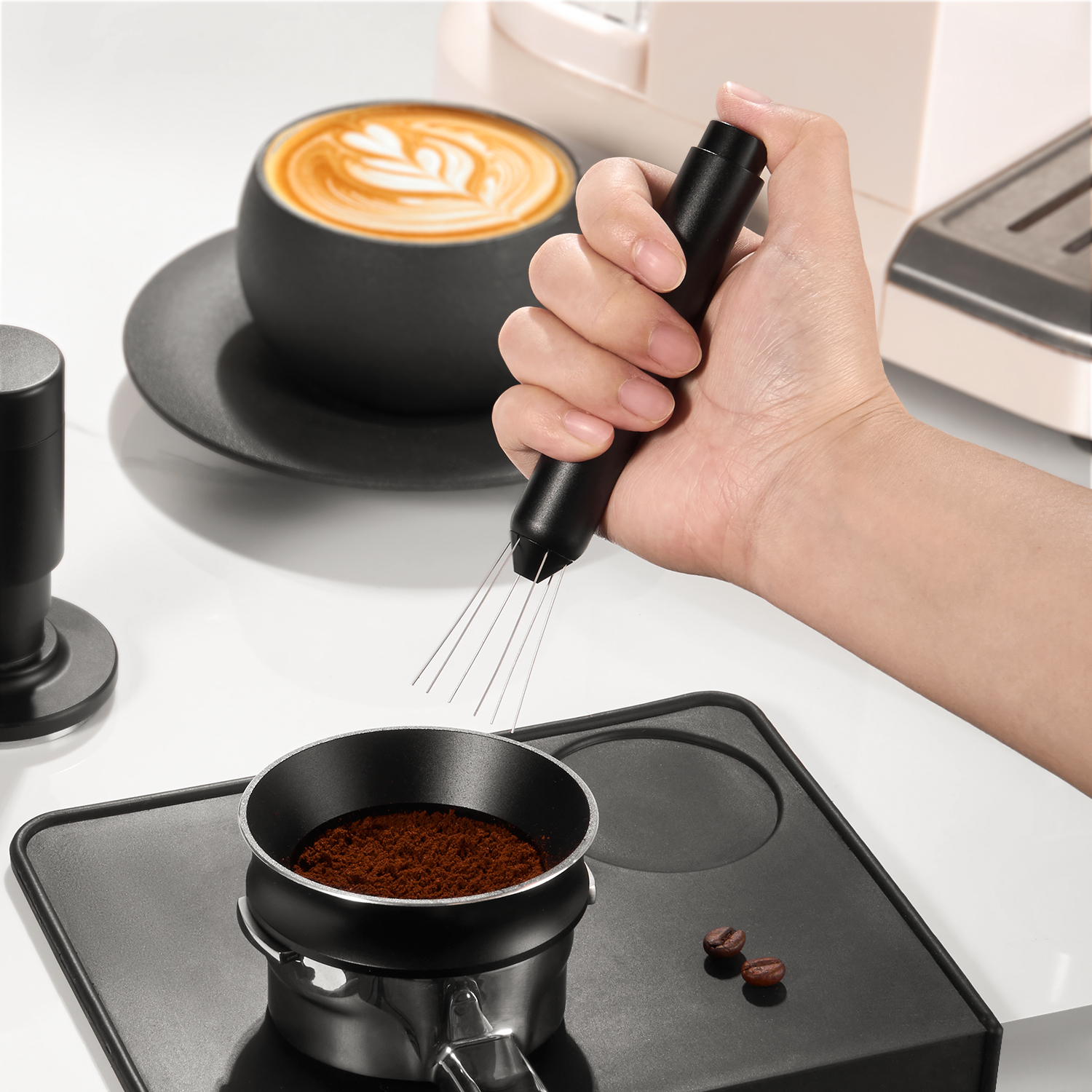 Handheld push-action WDT tool above a coffee basket