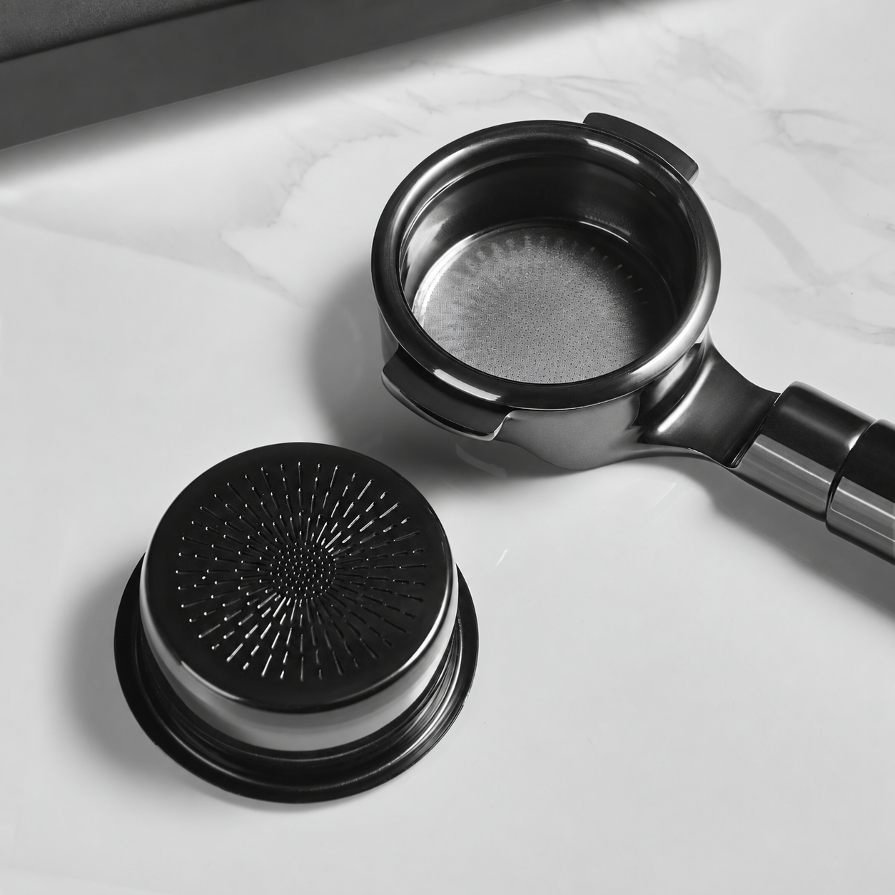 Double-layer espresso basket in a portafilter beside a basket base