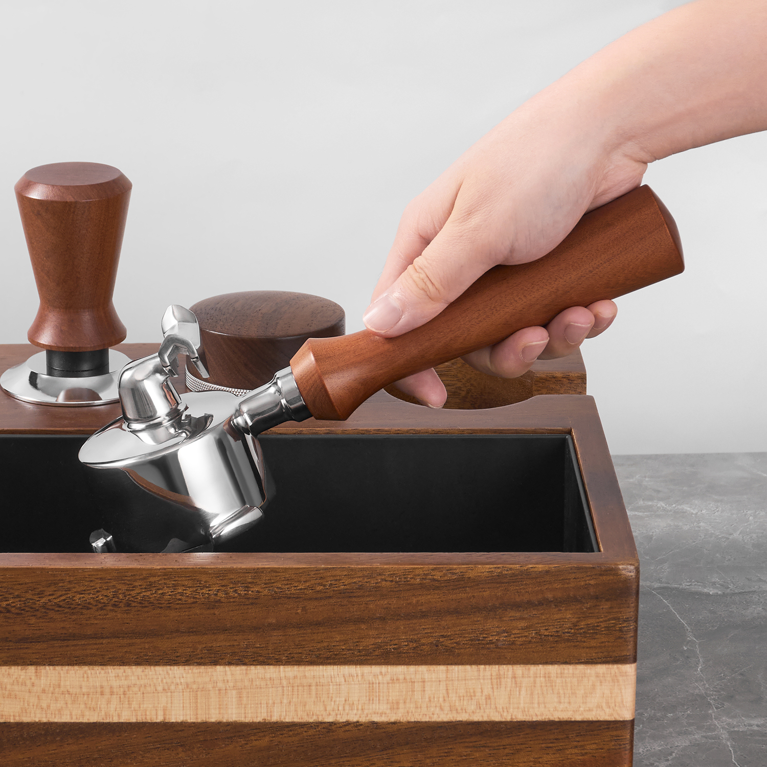 Three-lug portafilter in use beside a knock box