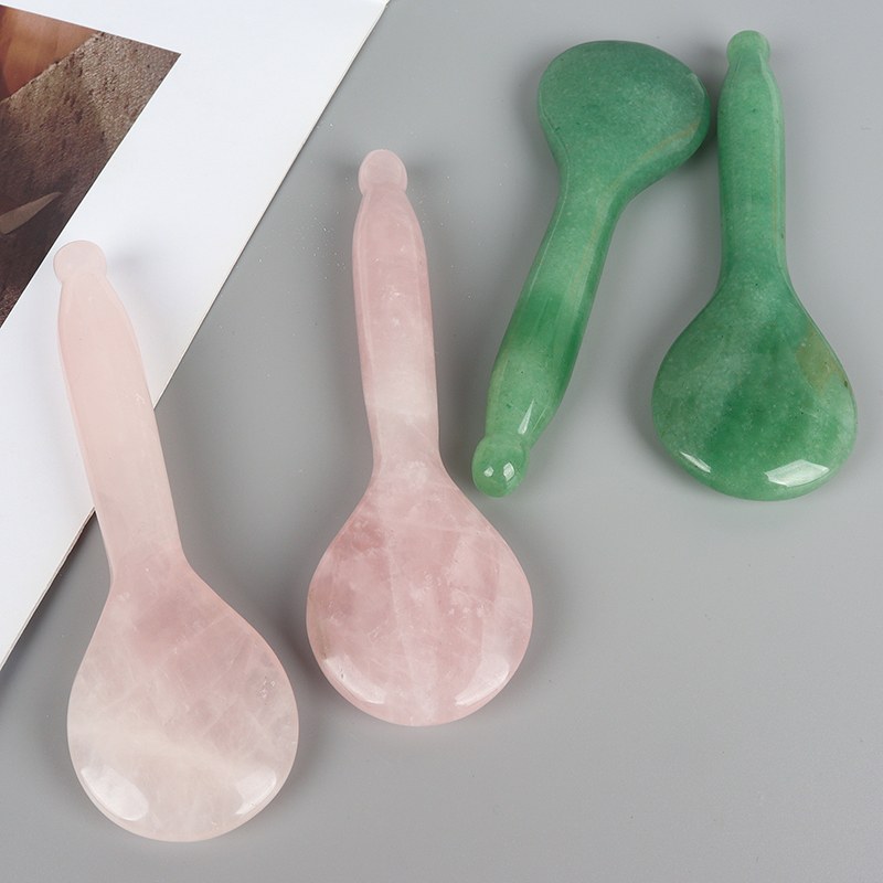 Rose quartz and green jade spoon gua sha tools flat lay