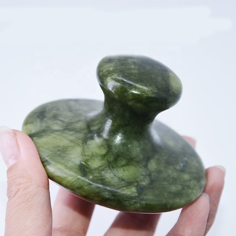 Mushroom massager held between fingers, green xiuyan grain