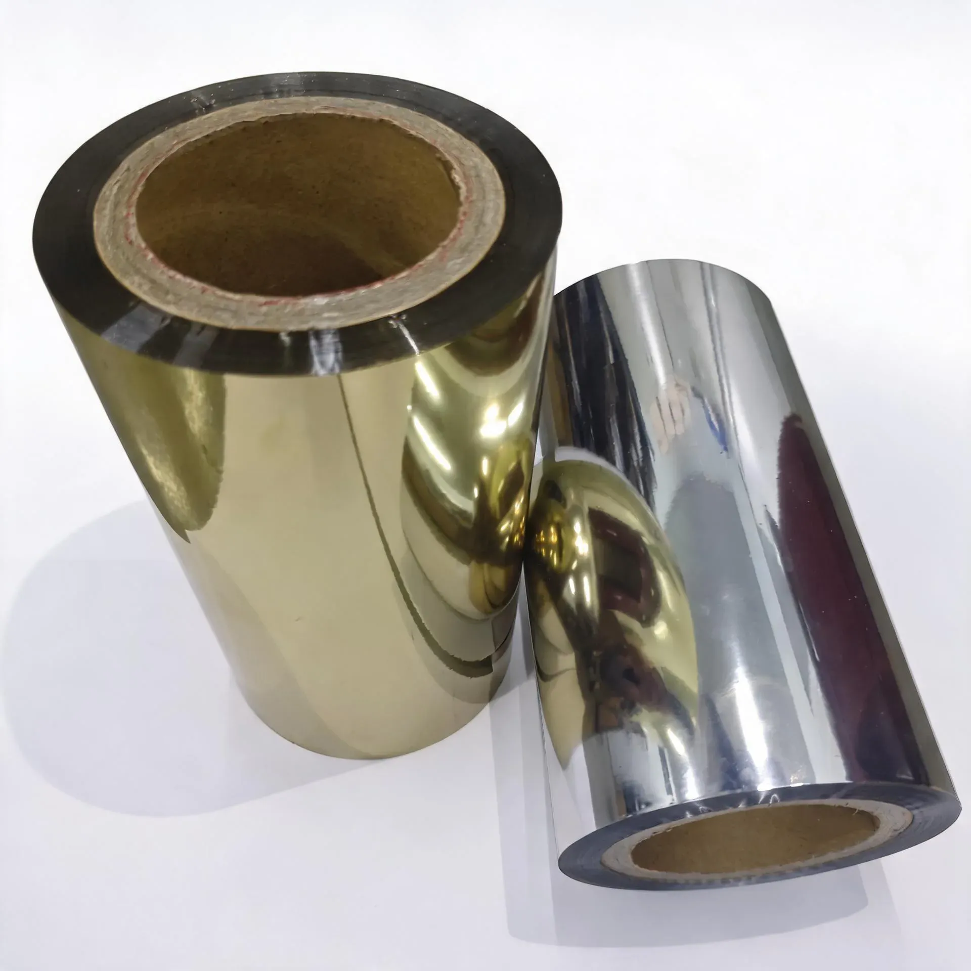 Gold and silver cold stamping foil rolls on a white background