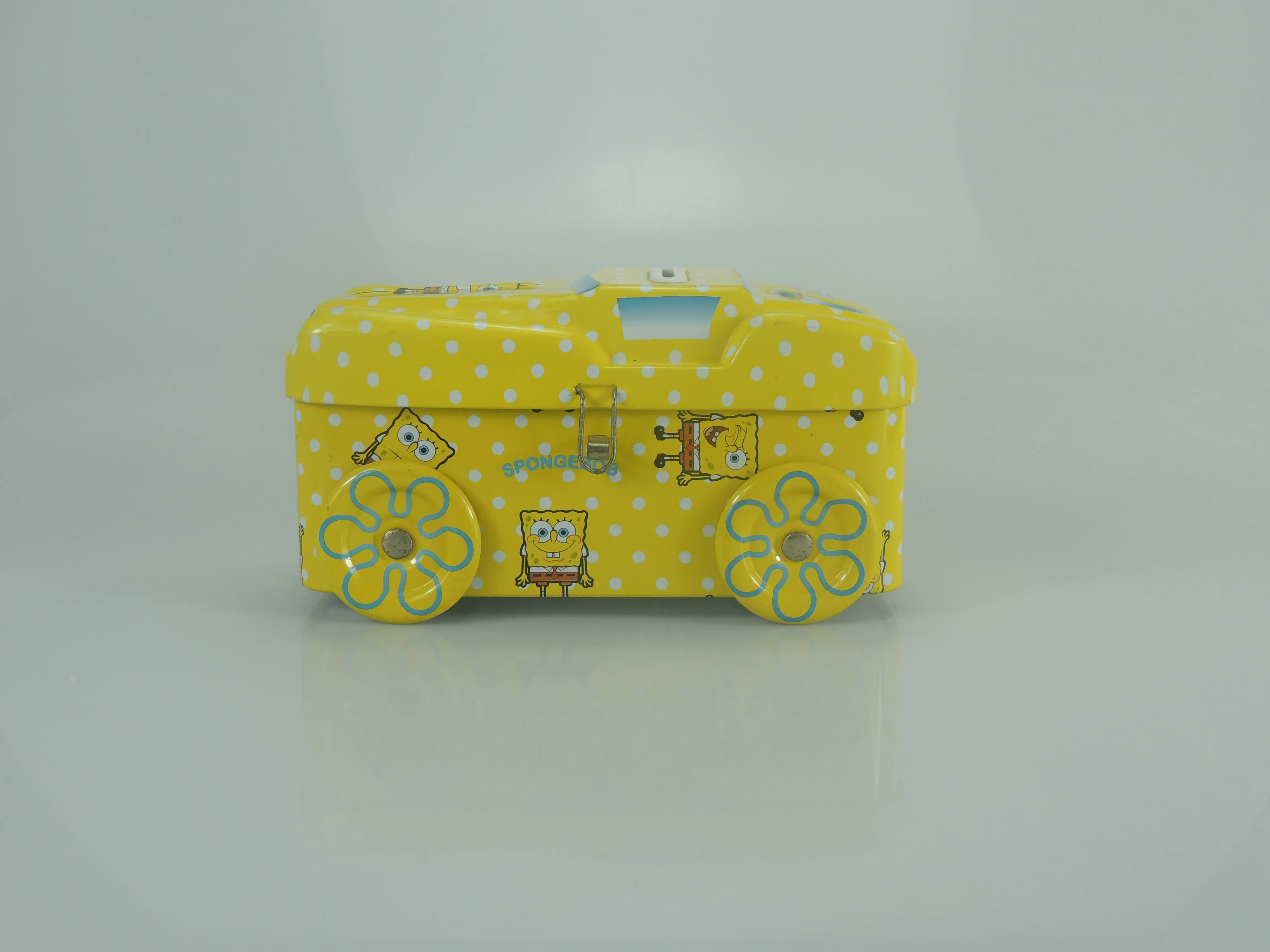 Bus-shaped tin in yellow with white polka dots and flower wheels