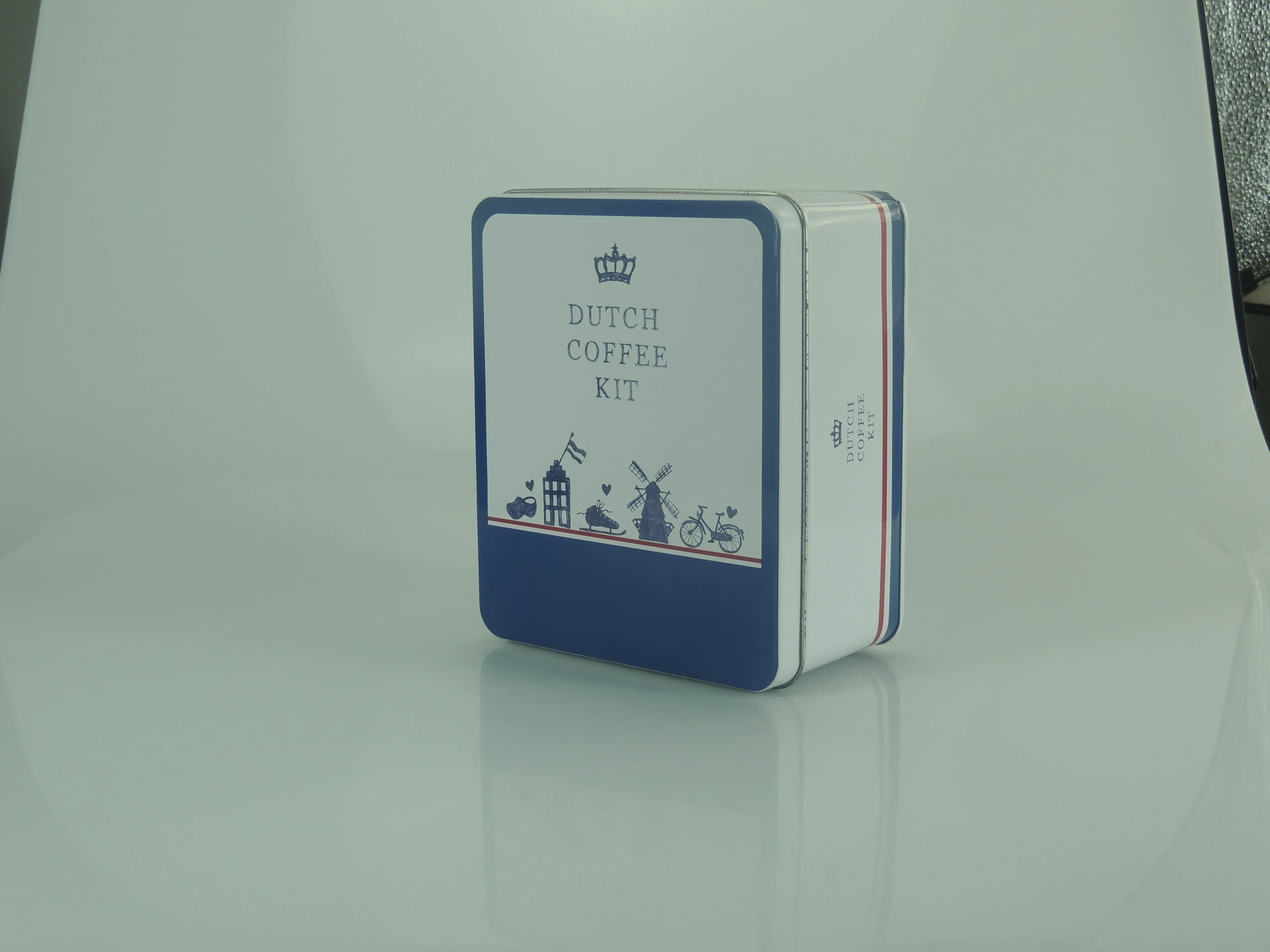 Square coffee-kit tin seen at an angle, showing the printed side panels