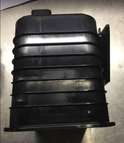 Side view of an injection molded automotive fuel vapor canister housing with external ribs