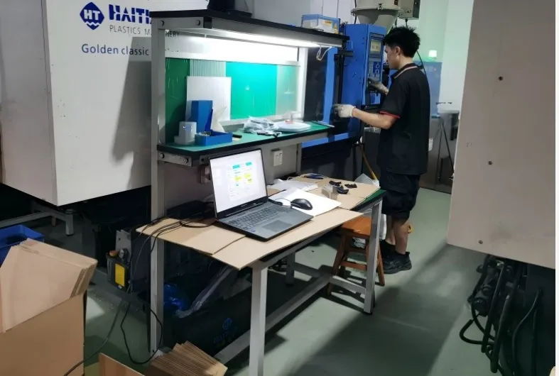 Engineer conducting scientific mold trial and data logging on a Haitian machine