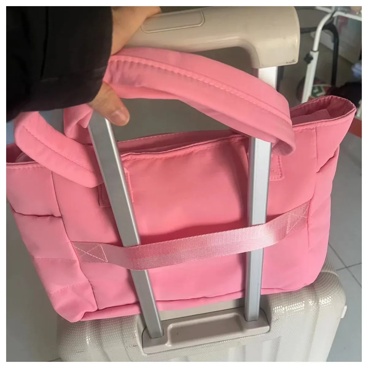 Pink padded commuter tote on a suitcase handle