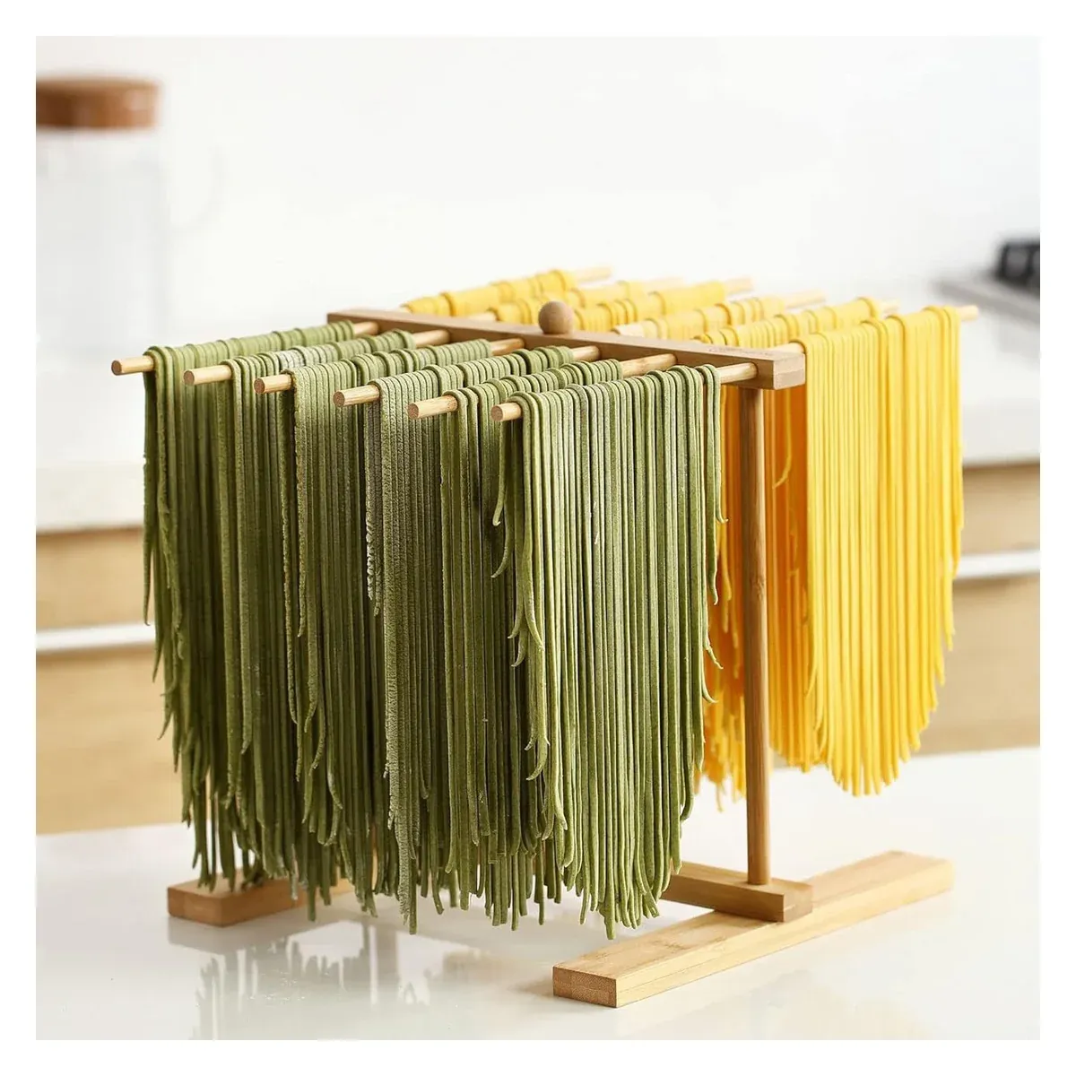 Wooden pasta drying rack holding fresh green and yellow pasta