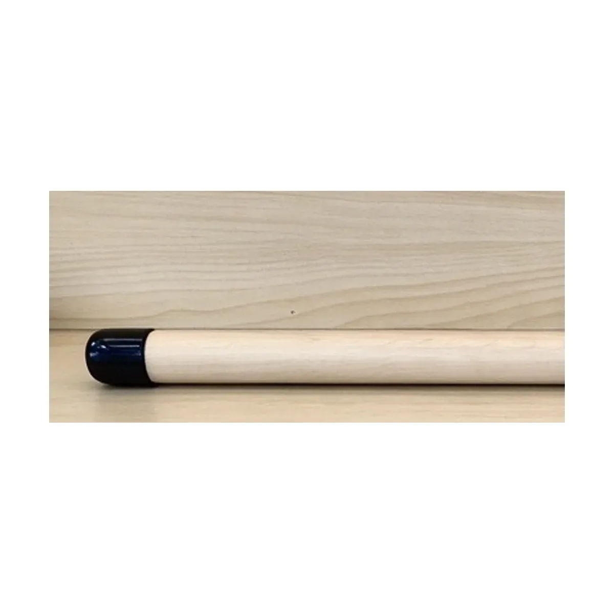 Left end of the maple wood Pilates training stick showing the black anti-slip end cap