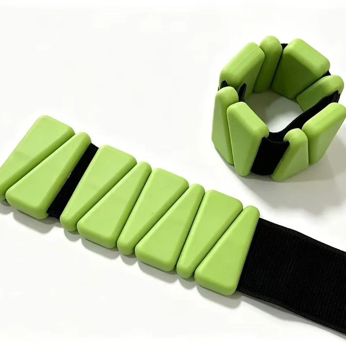 Green triangle-shaped ankle and wrist weights with wedge-shaped blocks, one strap flat and one bent into a circle