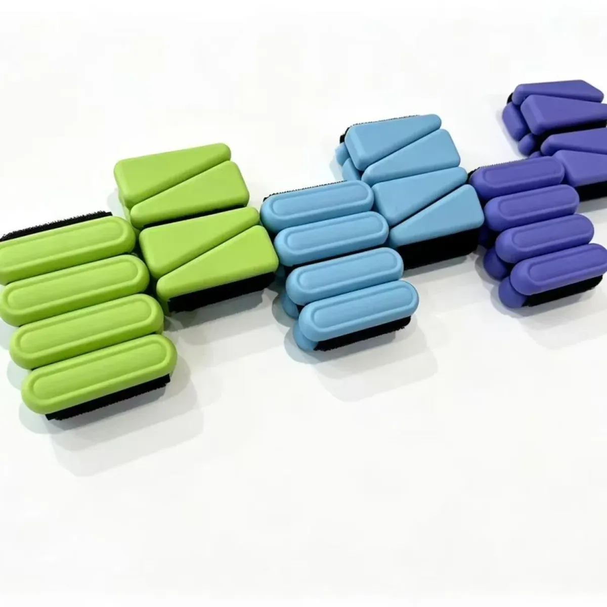 Ankle and wrist weights in green, blue and purple, with the triangle and the oval version shown in each colour