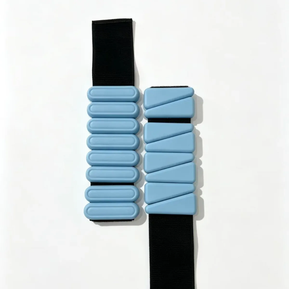 Blue ankle and wrist weights in both shapes side by side, oval blocks on the left and triangle blocks on the right