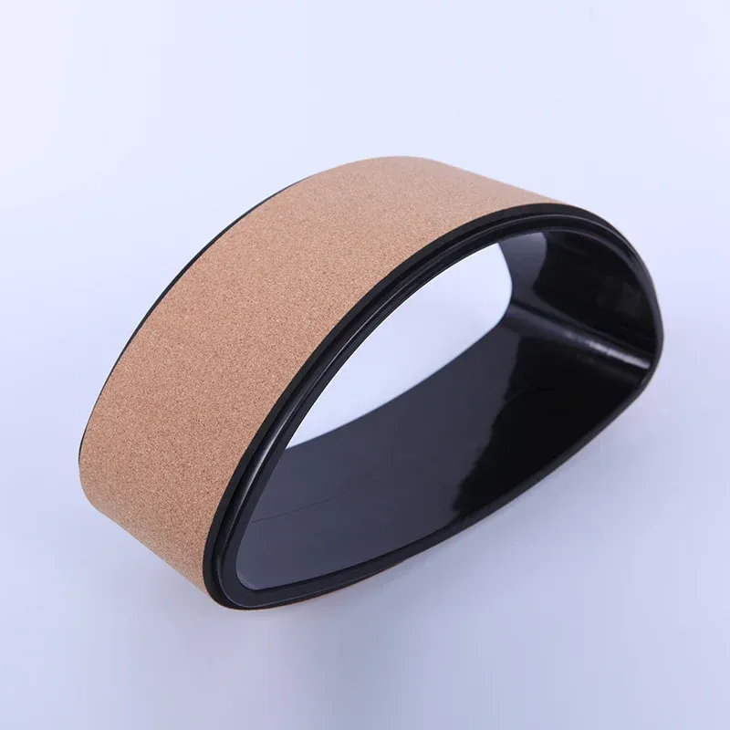 Shaped cork yoga wheel with a glossy black rim and a natural cork outer surface, on a white background
