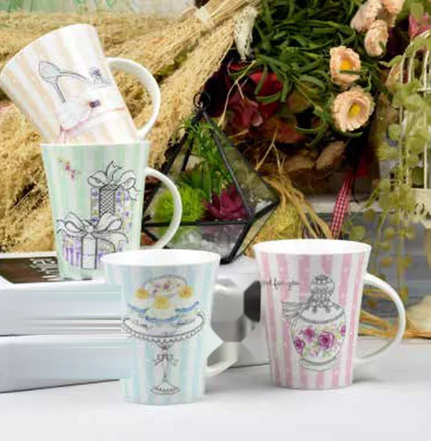 Four pastel striped ceramic mugs with black line-art drawings of a dessert stand, a ribboned gift box, a high heel and a perfume bottle