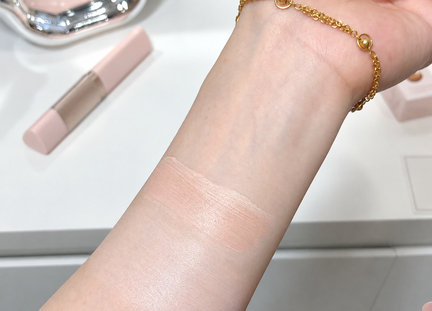 A swatch of the foundation blended on the inner forearm showing the developed shade