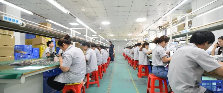 Worker assembling a massage device with electric screwdriver at ZonyouTech OEM factory in Shenzhen, China