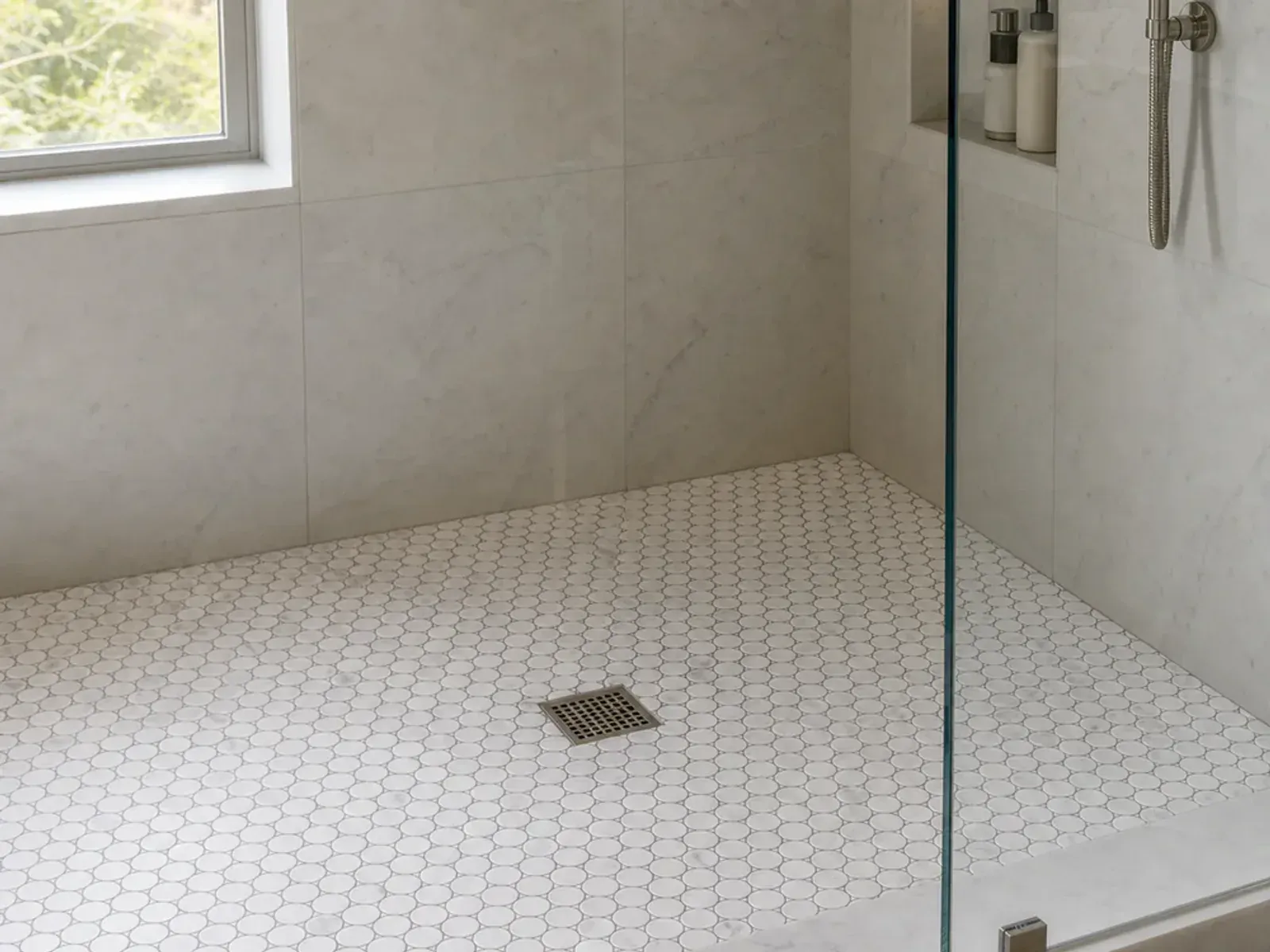 Carrara White Marble Penny Round Mosaic Tile installed in a shower application