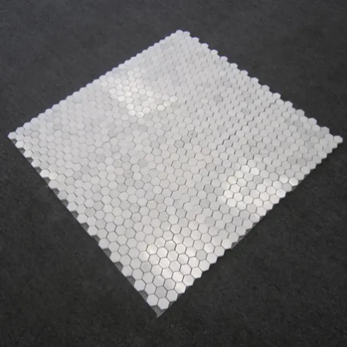 Close-up of Carrara White Marble 1 Inch Hexagon Mosaic surface and joints
