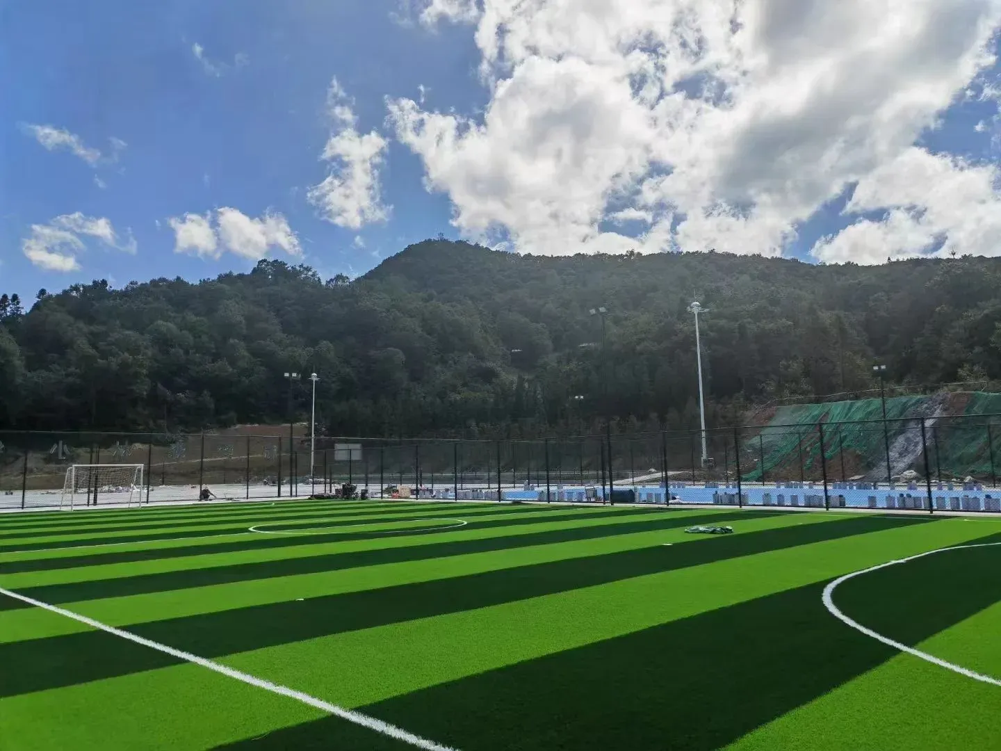 Artificial football turf pitch with white markings and perimeter fence
