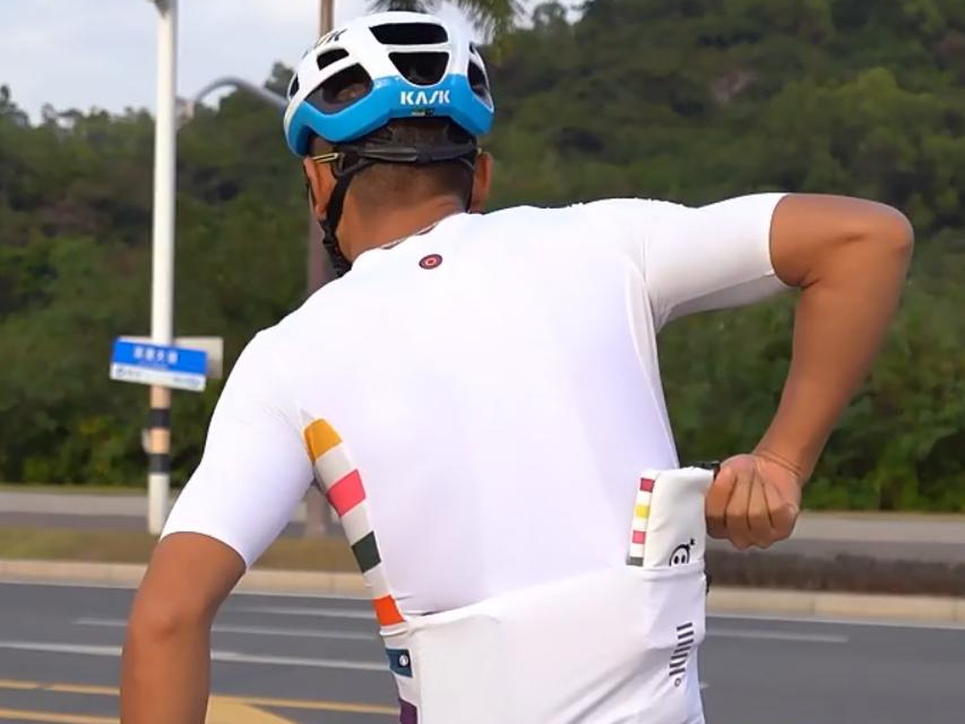 Rider taking a cycling wallet from the jersey back pocket on the road