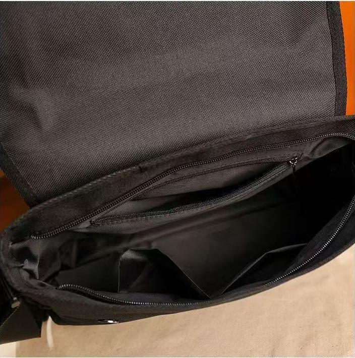 Inside view of the black musette bag showing the main compartment, a zippered inner pocket and divider sleeves