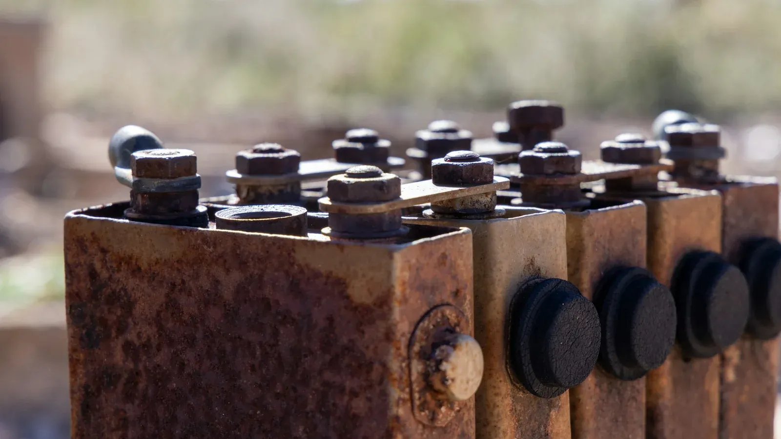 Close-up of old battery cells with rusted terminals and corroded casings