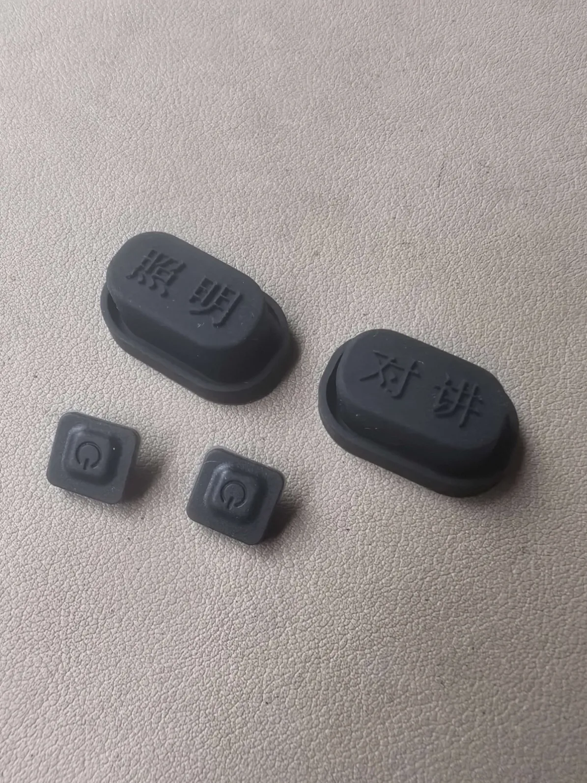 Rubber button caps with molded legends for lighting and intercom functions