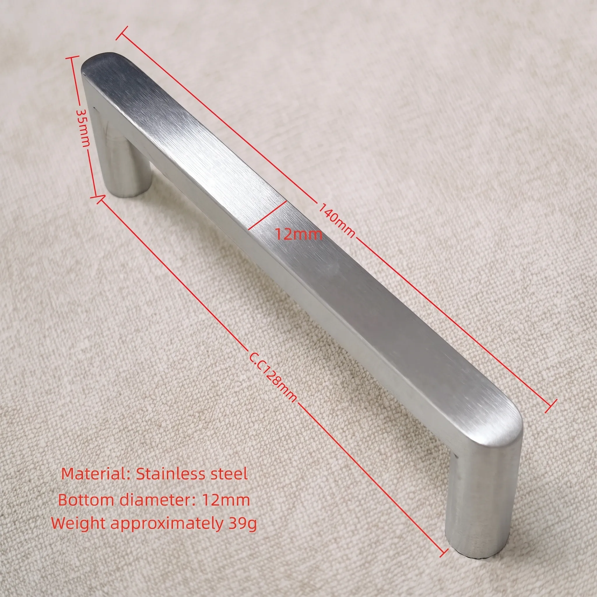 Linen photo of the polished flat-sided stainless pull annotated in red with a 35 mm projection, 140 mm overall length, 12 mm diameter and 128 mm center-to-center spacing, plus a stainless steel material note and a 39 g weight line