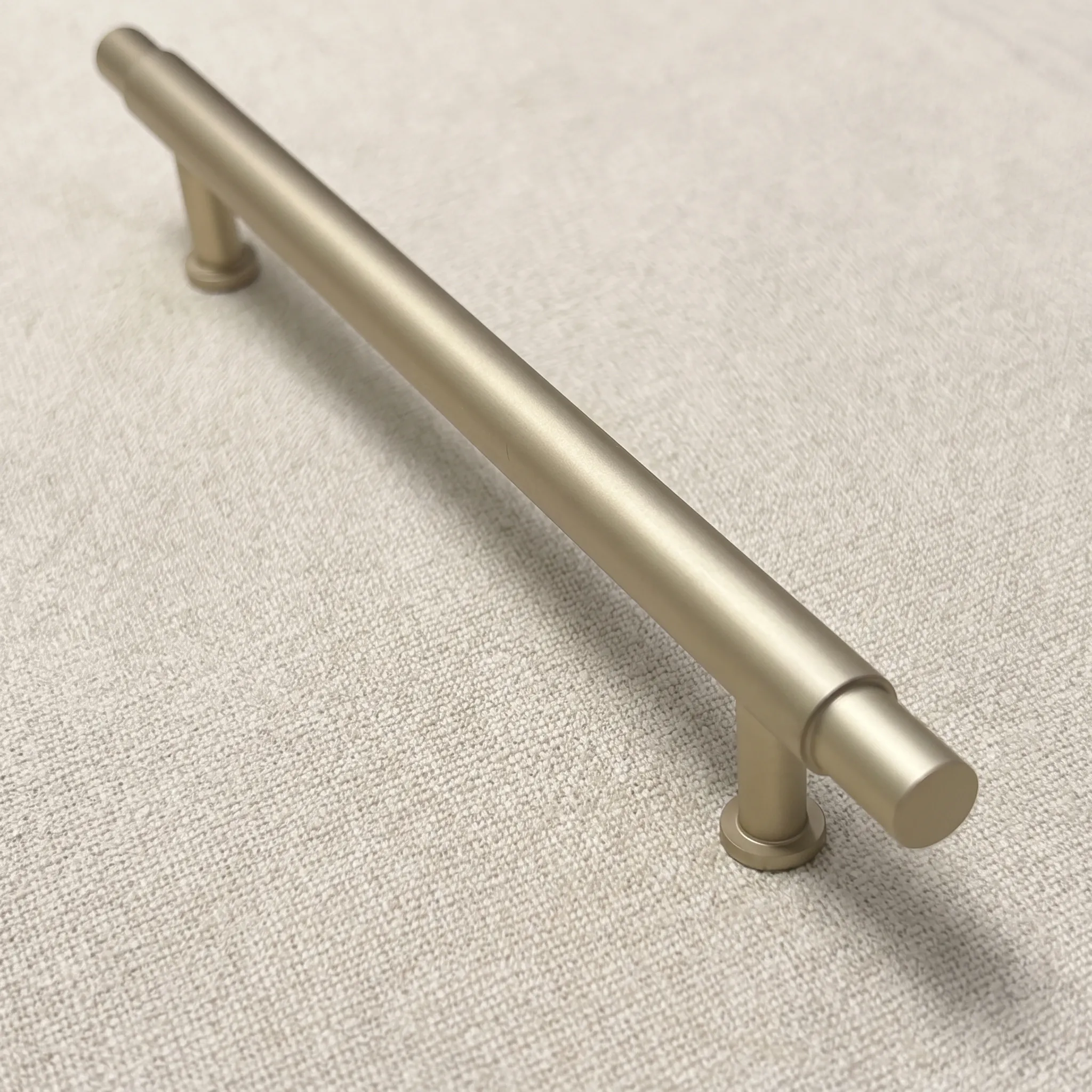 Angled view of the Matt Gold smooth T-bar cabinet pull with a round bar, twin cylindrical posts and stepped beveled ends