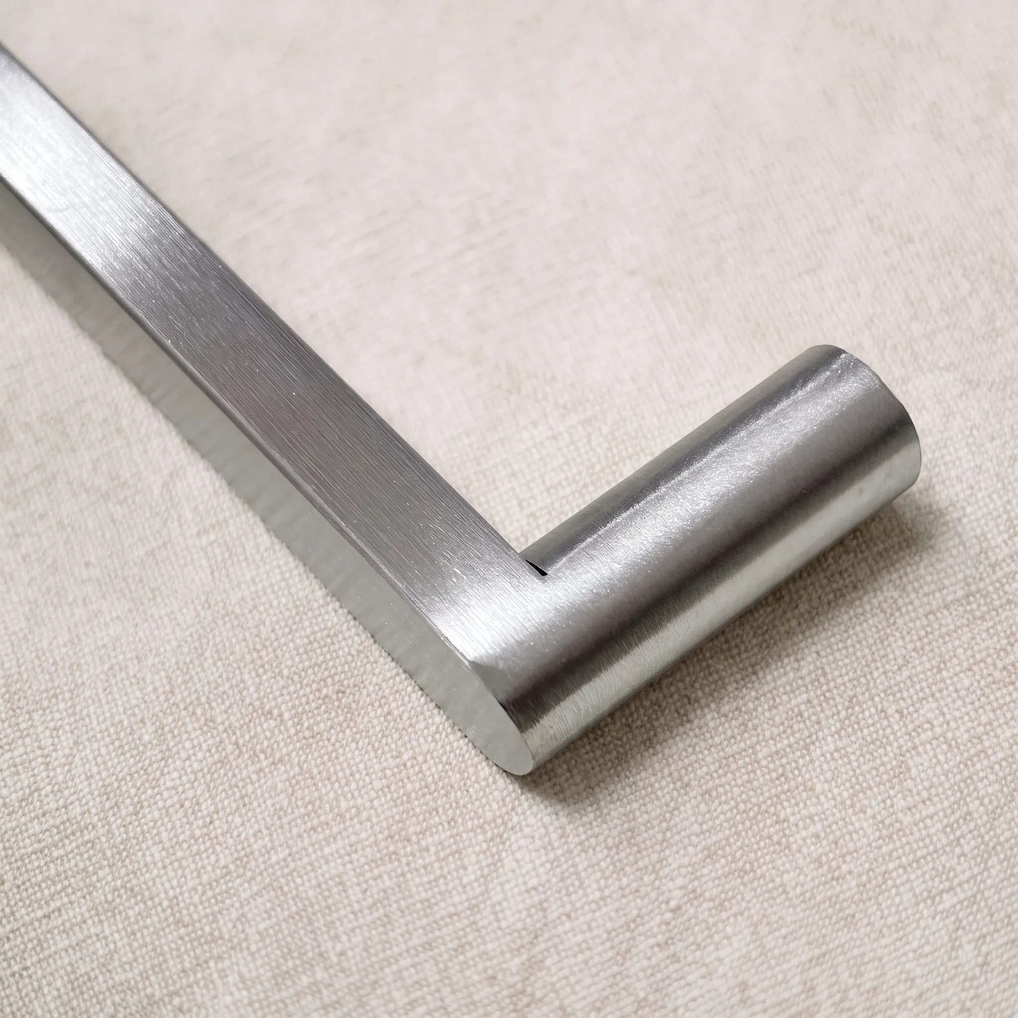 Close view of the joint where the polished flat band steps down into a round leg on linen