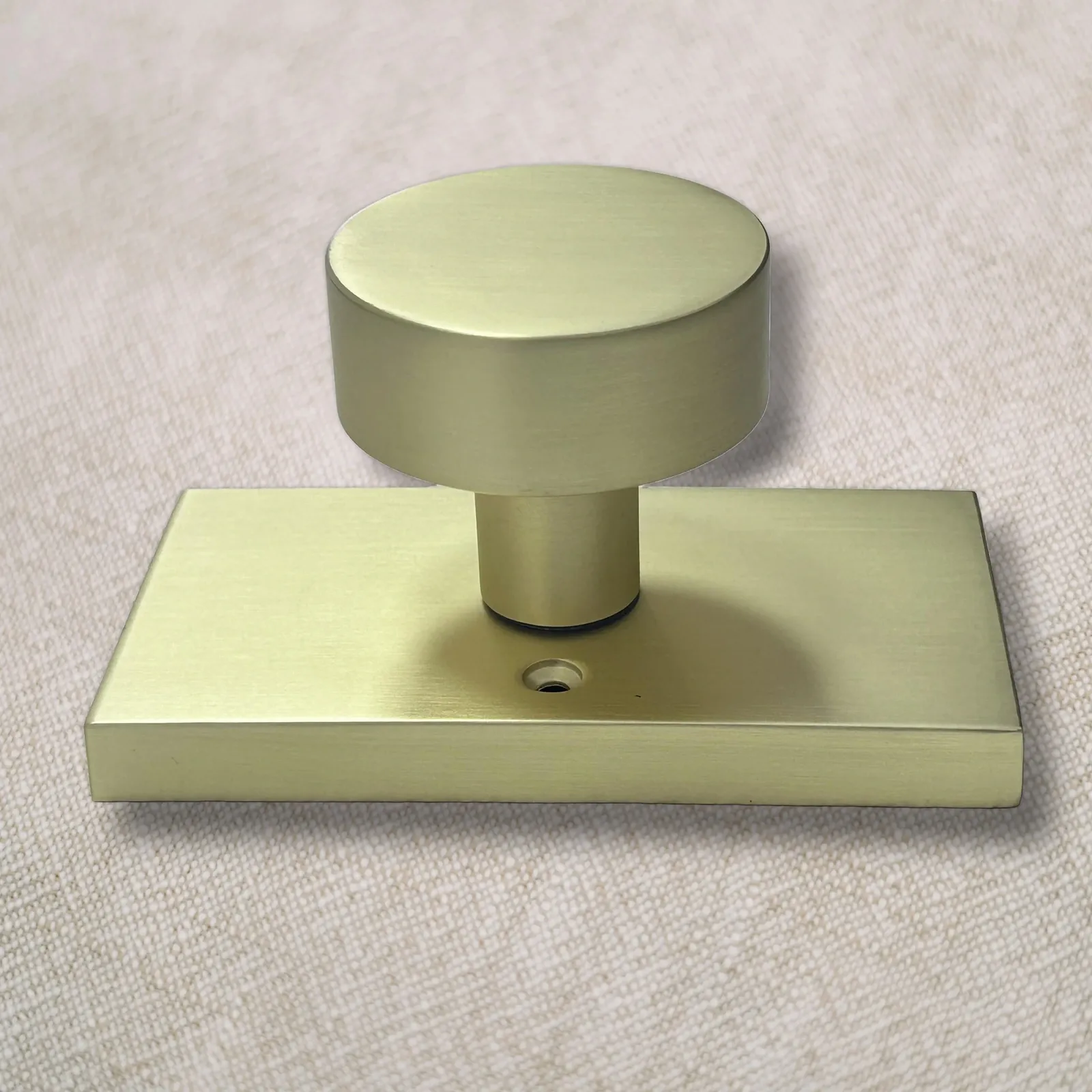 Side profile of a brushed gold door knob showing the stem and rectangular rose plate