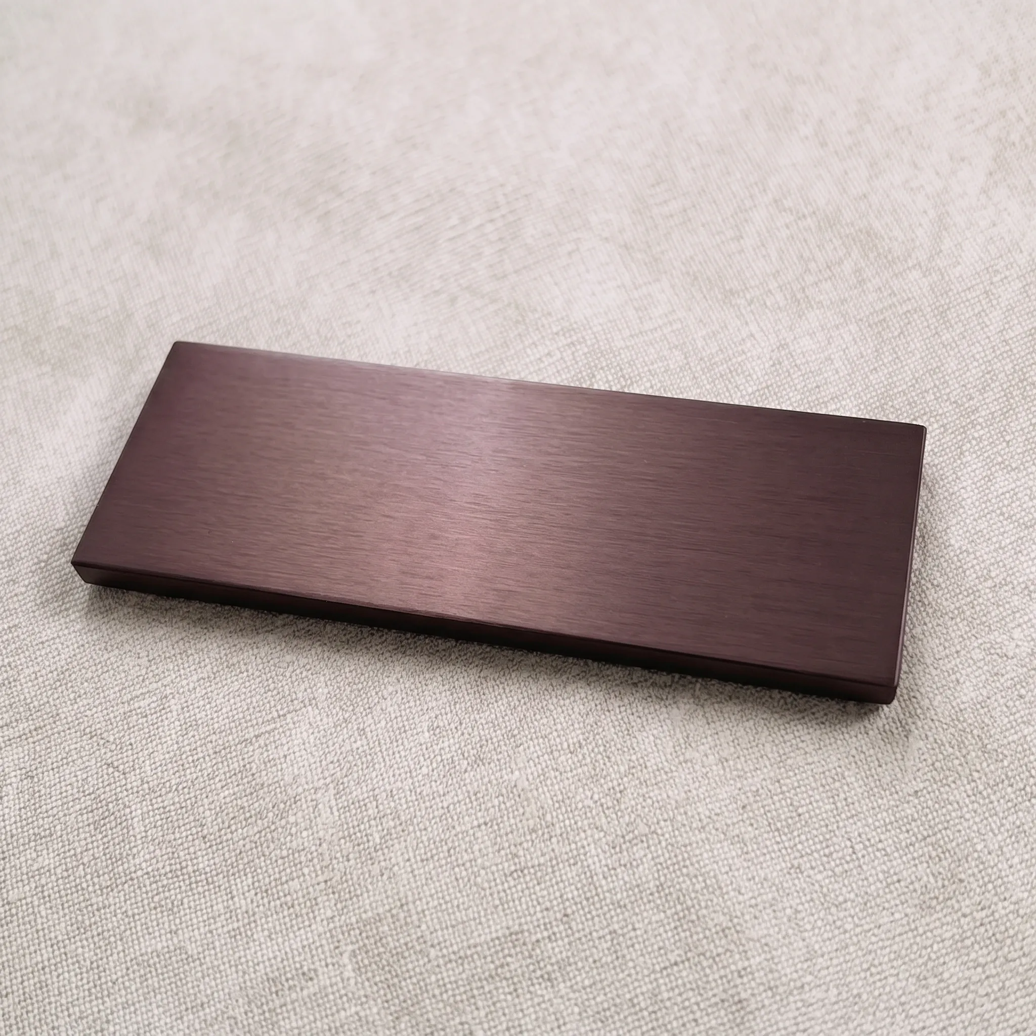 Brushed coffee side-mounted edge pull lying flat on linen, showing the full rectangular face plate