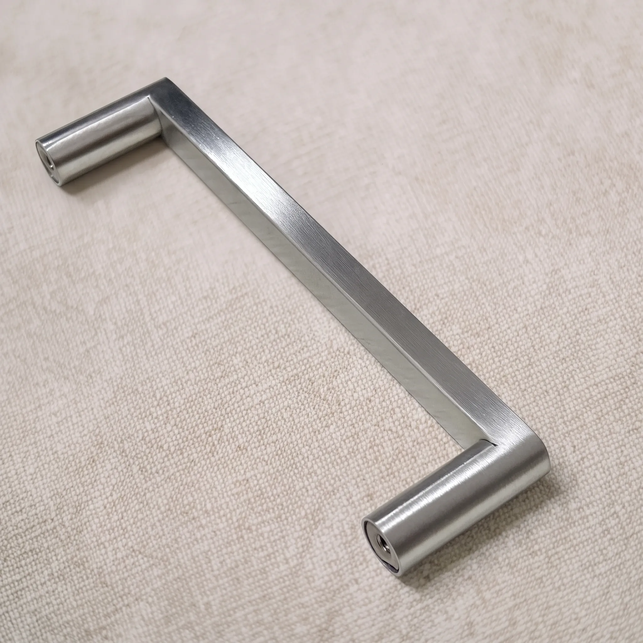 Angled view of the polished flat-sided pull on linen, with one round leg facing the camera to show the bore in its end