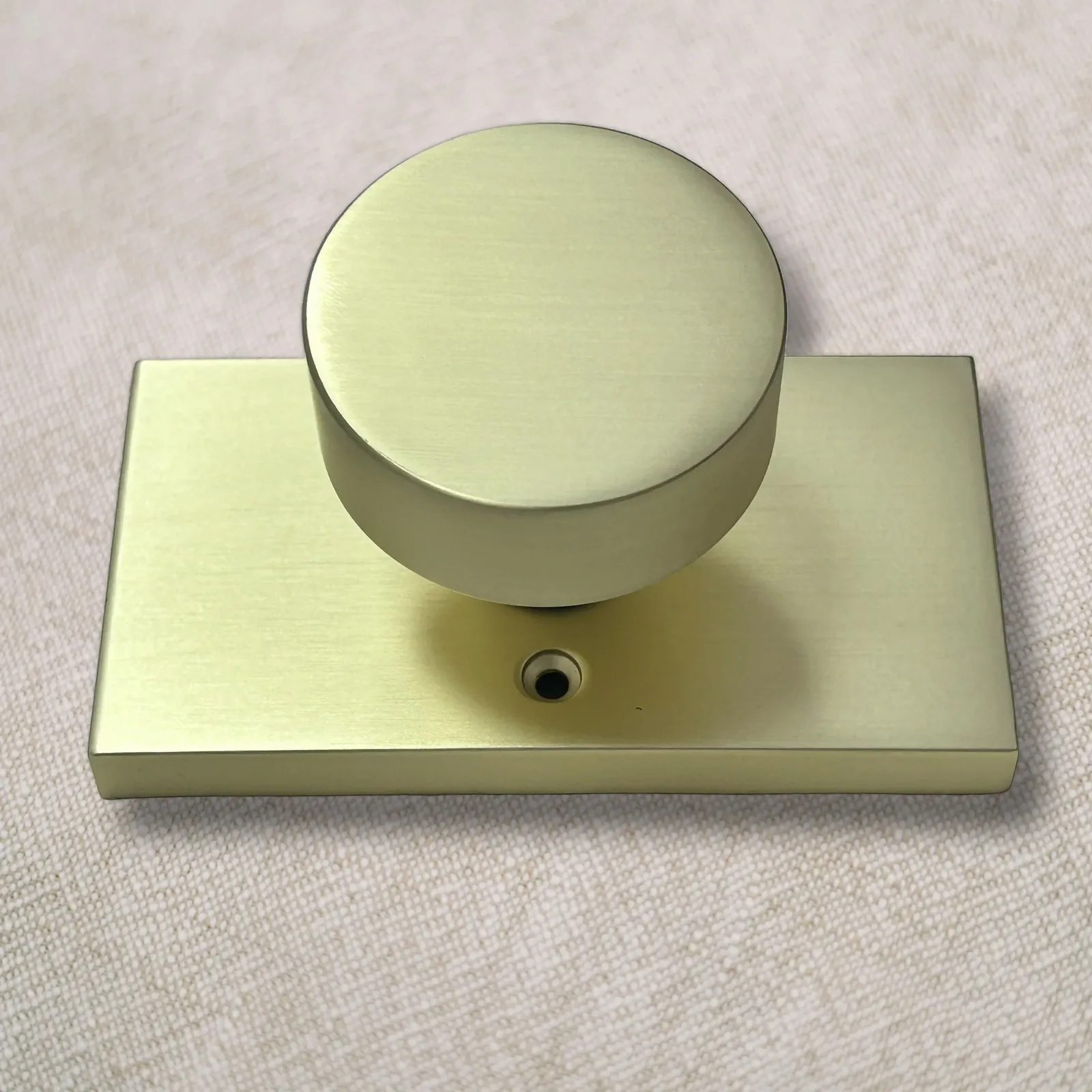 Brushed gold door knob viewed from above on its rectangular rose plate