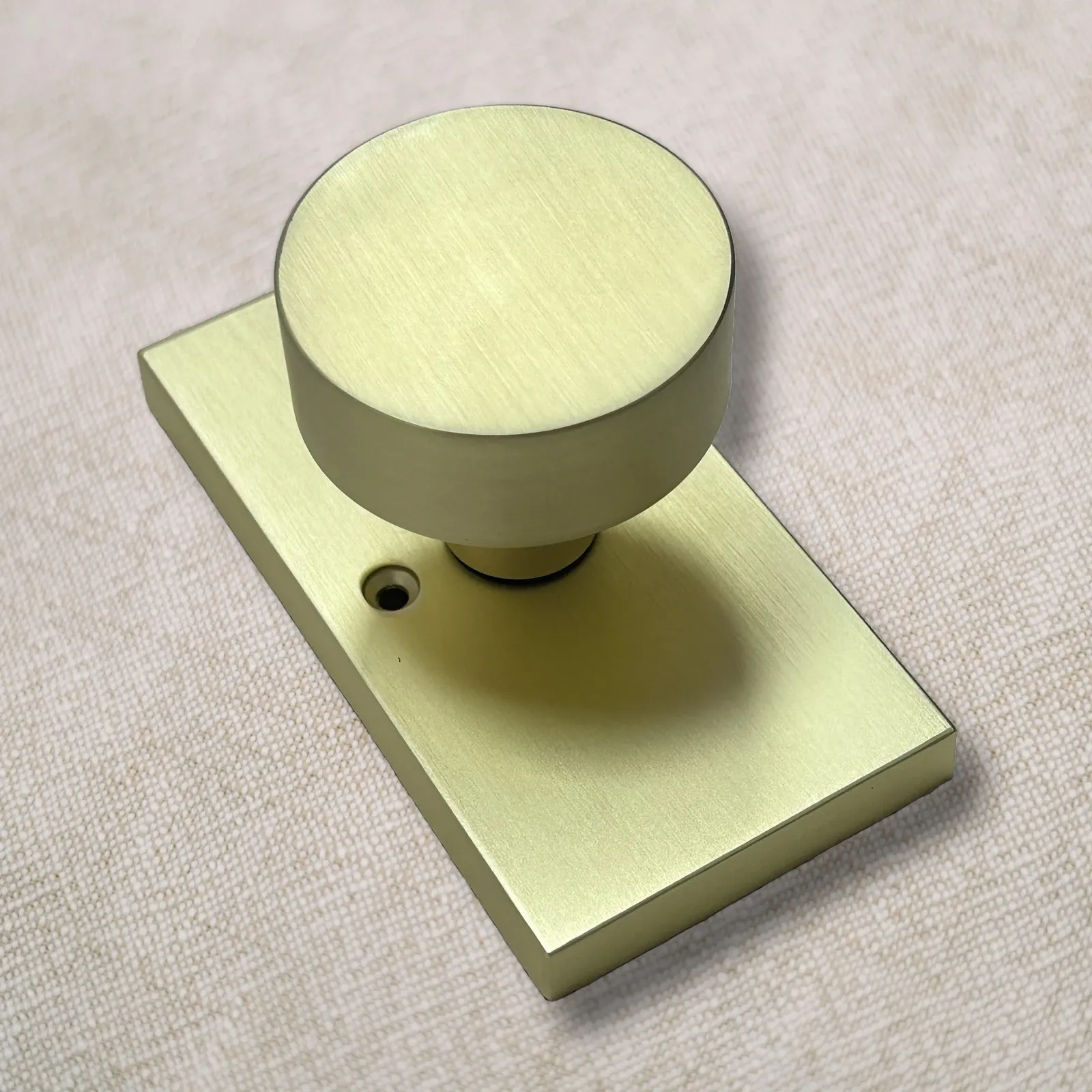 Brushed gold door knob with rectangular rose plate shown at a three-quarter angle
