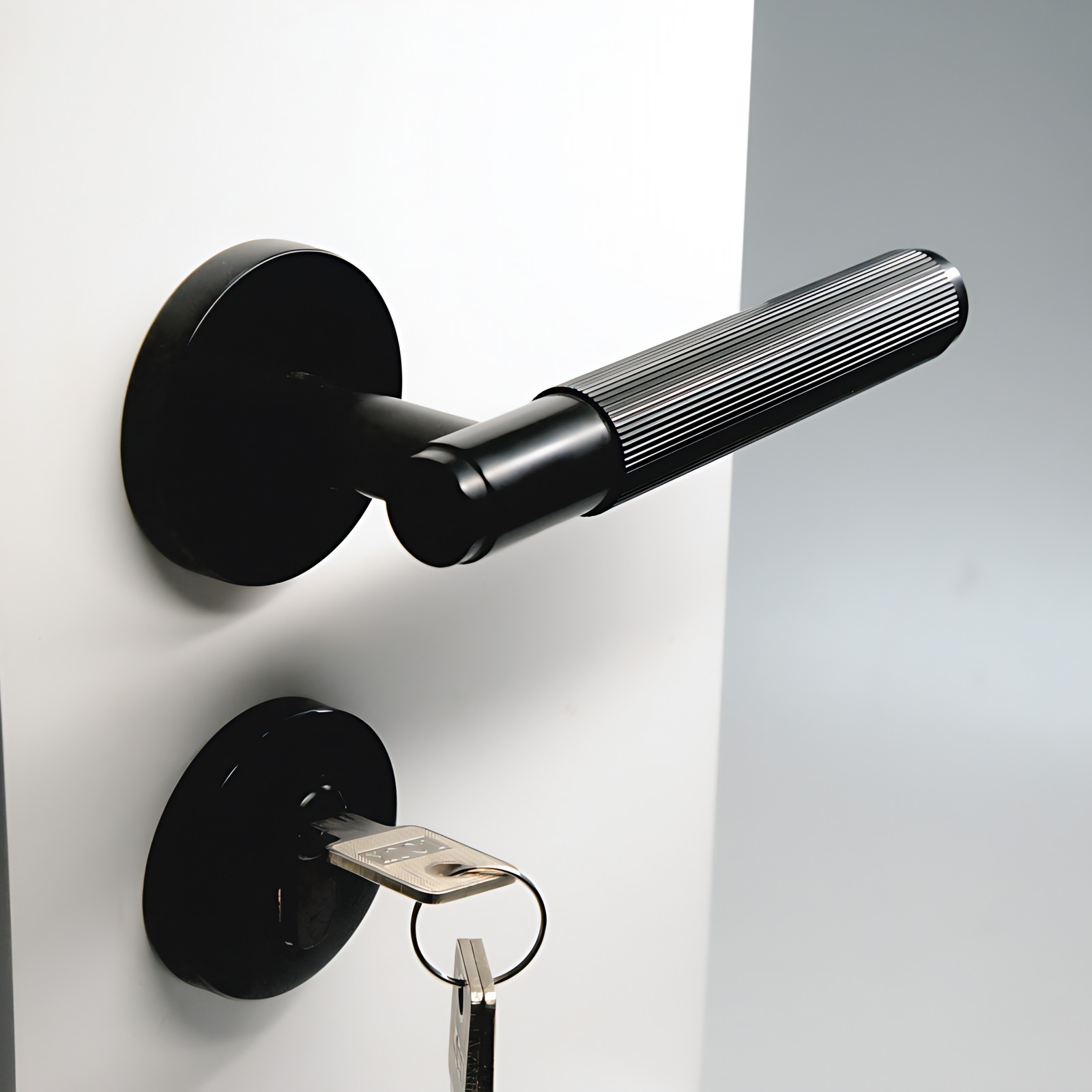 Angled view of a matt black fluted lever door handle on a round rose, mounted on a white interior door
