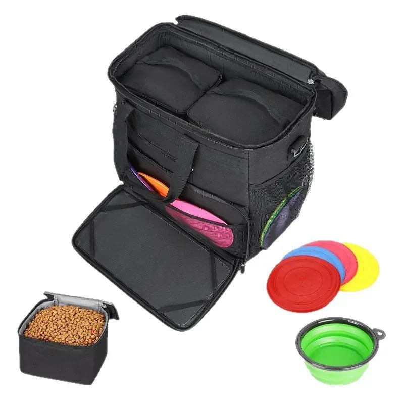 Black pet travel bag with food bowls, lids and kibble laid out in front of it