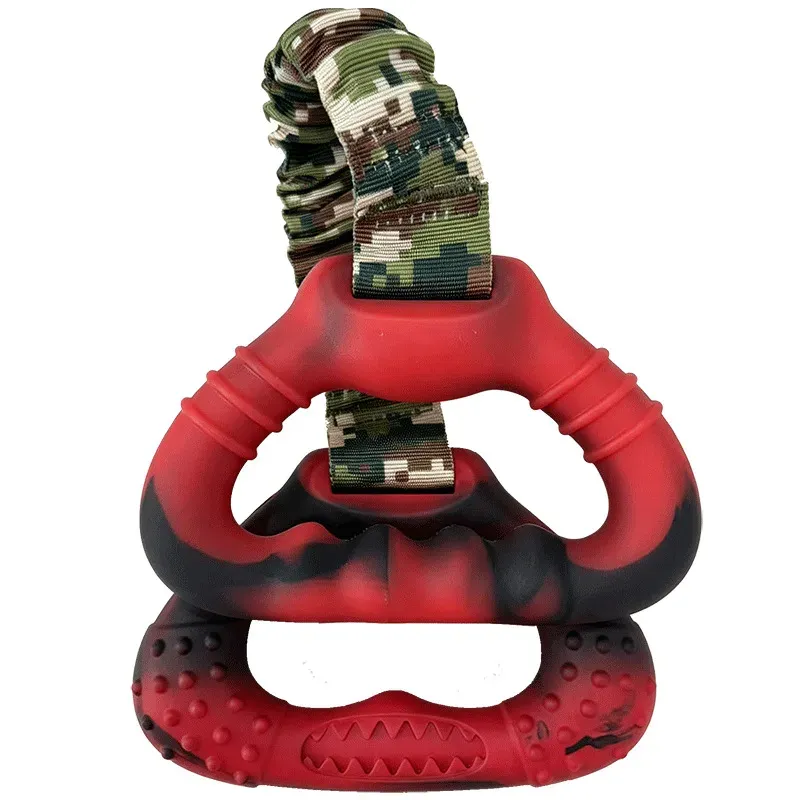 Red and black rubber dog tug toy with camouflage strap and a textured rubber grip