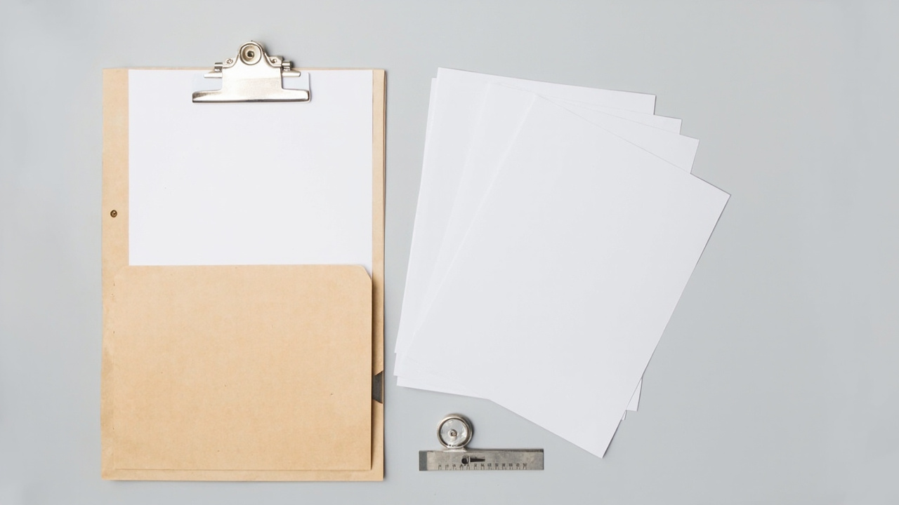 Blank toy safety test documents, a clipboard and a measuring tool on a light desk
