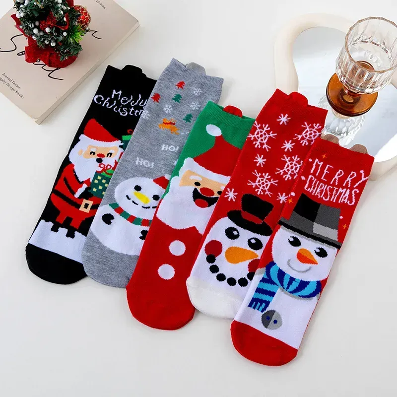Flat lay of five Christmas socks with Santa, snowman and Merry Christmas patterns in red, grey and white
