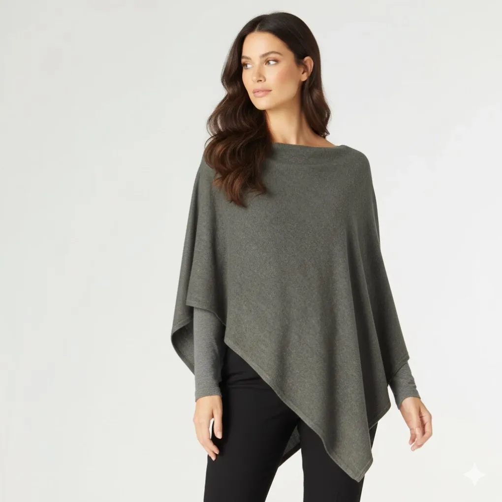 Front view of an olive green lightweight knit poncho with an asymmetric drape, layered over a grey long-sleeve top