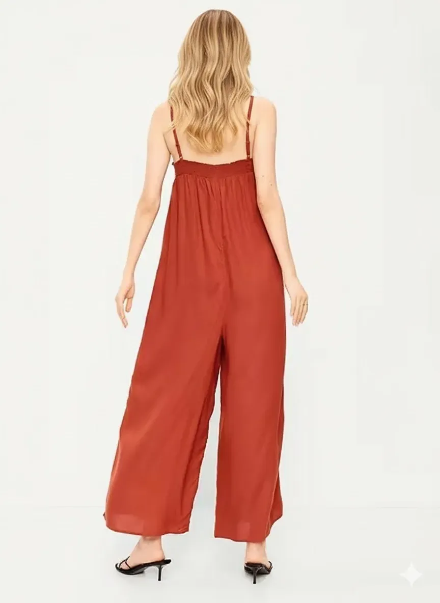 Back view of the rust viscose jumpsuit showing the smocked bodice and flowing wide legs