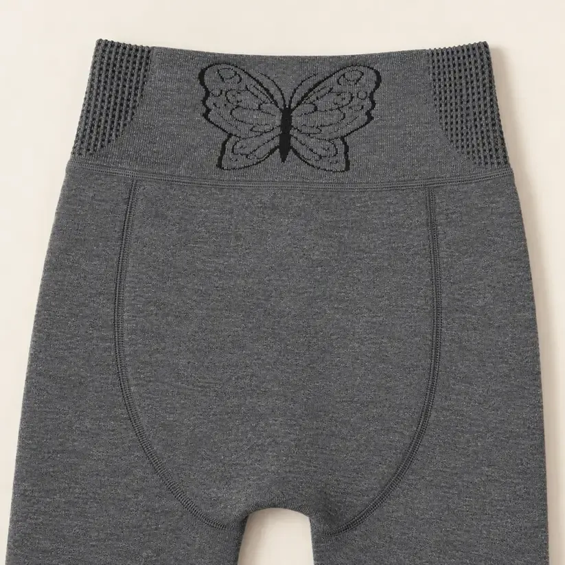 Charcoal grey leggings with a butterfly-pattern waistband and curved rear panel seams.