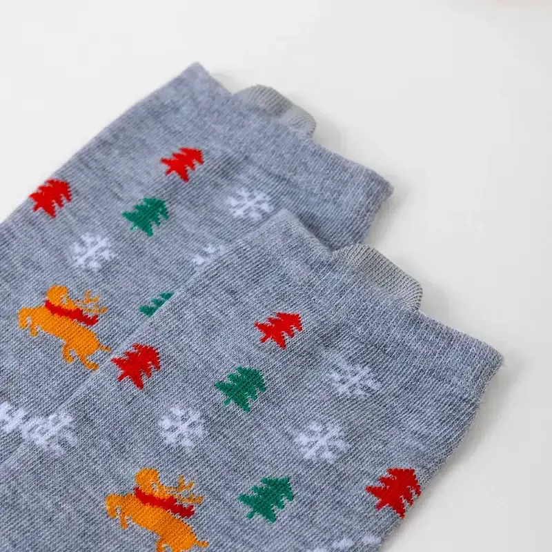 Folded grey Christmas socks with reindeer, snowflake and Christmas tree patterns