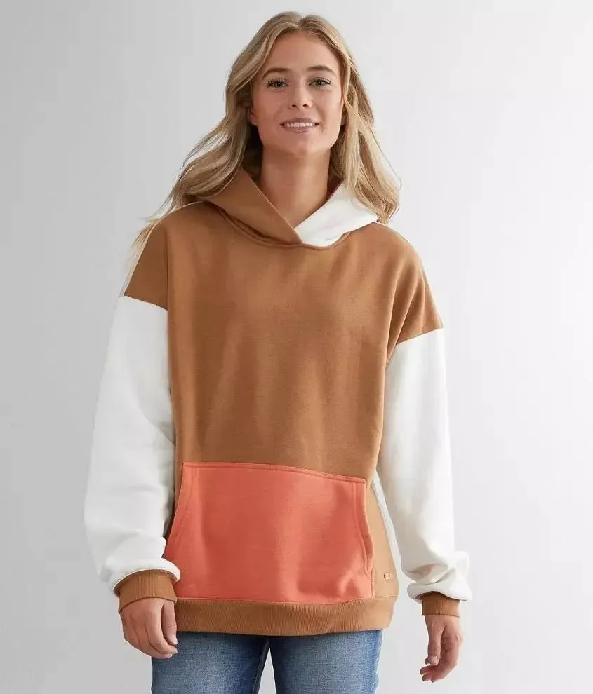 Front view of women's oversized color-block pullover hoodie in camel with cream sleeves and coral kangaroo pocket
