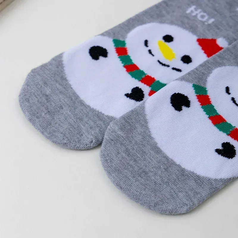 Pair of grey Christmas socks with snowman faces and red scarves