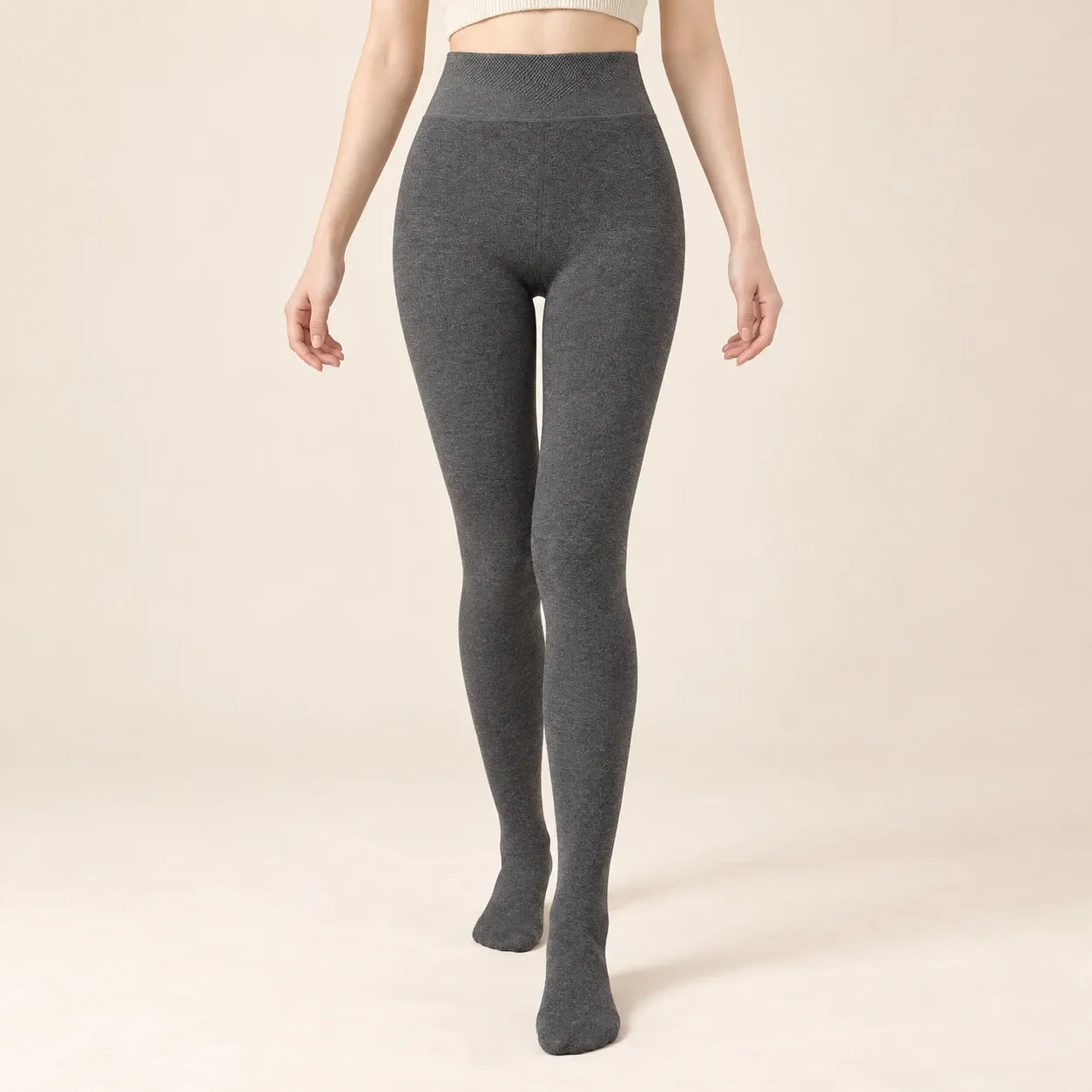 Model wearing charcoal grey high-waisted fleece-lined footed leggings, styles 6001 and 6002, front view.